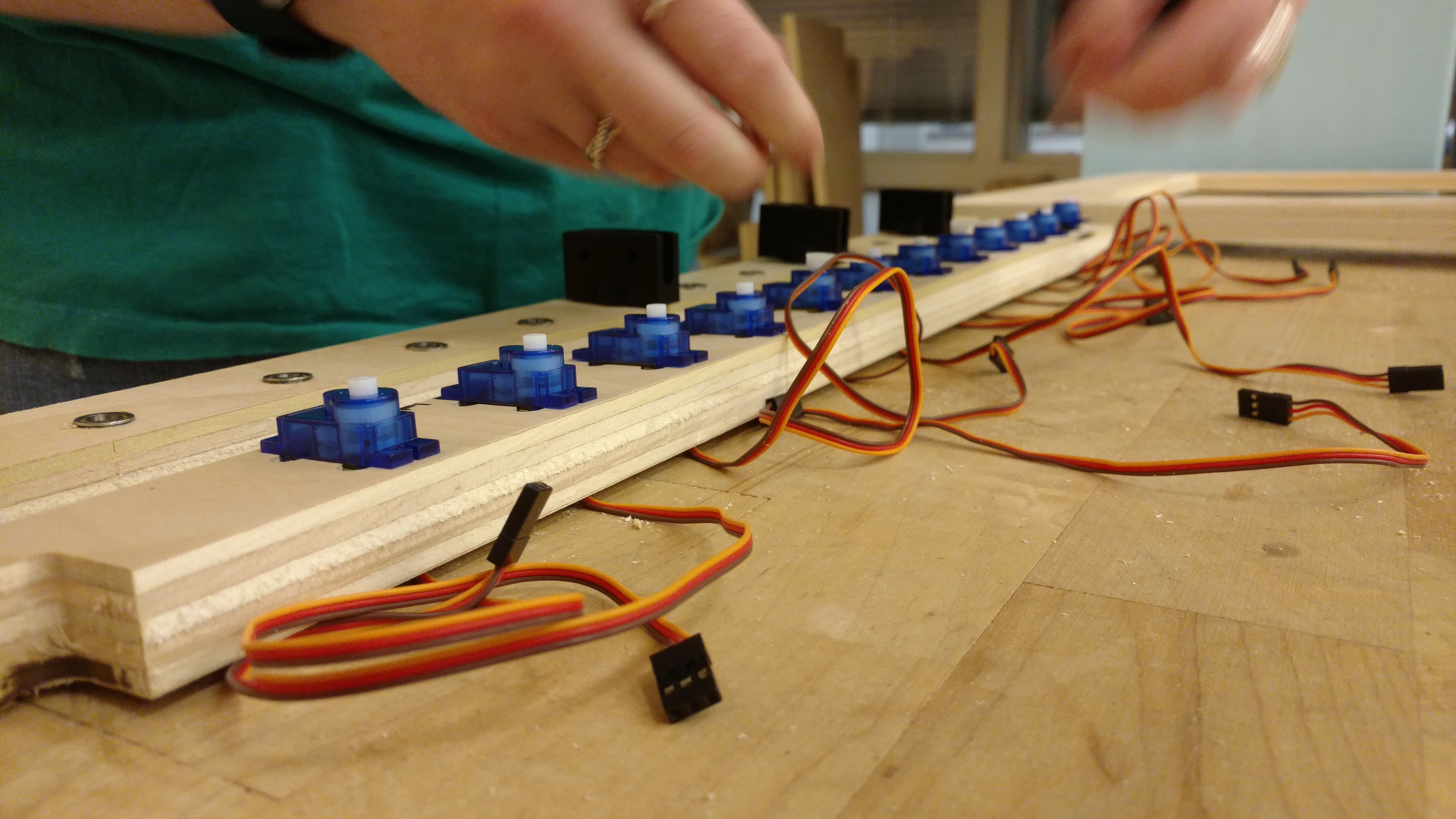 A view of our servo mounting in progress. All servos are press fit into their holes with the wires sticking out.